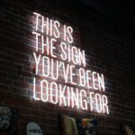 Neon sign saying "This is the sign you've been looking for" with a glowing effect.